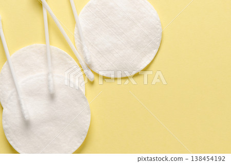 Cotton swabs and cotton pads for hygiene. Yellow background. Copy space Cotton swabs and cotton pads for hygiene. Yellow background. Copy space 138454192