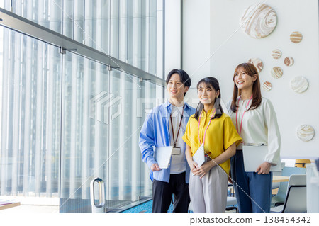 A smiling man and woman holding laptops. 138454342