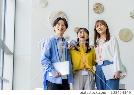 A smiling man and woman holding laptops. 138454349