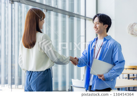 Male and female shaking hands 138454364
