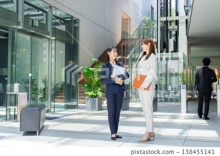 A young man and woman in suits, smiling. 138455141