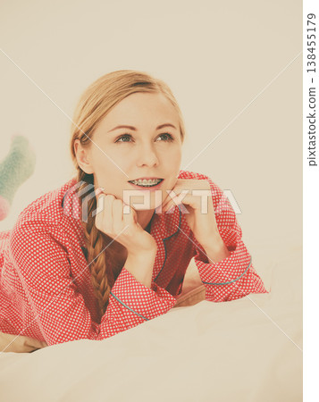 Smiling woman lying in bed Smiling woman lying in bed 138455179