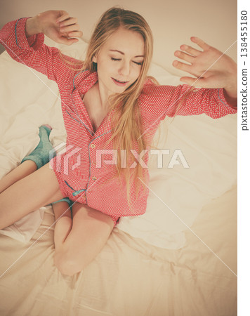 Awaken woman stretching body after sleeping 138455180