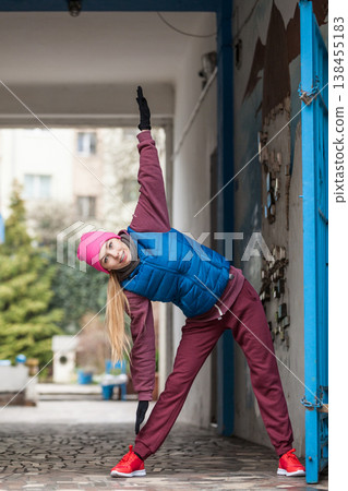 Sporty girl stretching outdoor on city street. Sporty girl stretching outdoor on city street. 138455183