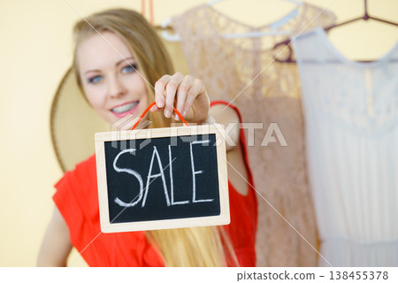 Woman in shop with sale sign Woman in shop with sale sign 138455378