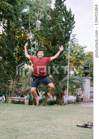 Dynamic Jump of Man in Red Shirt Captured Mid Air Dynamic Jump of Man in Red Shirt Captured Mid Air 138455864