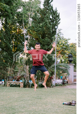 Happy Man Jumping in Red Outfit Celebrating Moment Outdoors 138455865