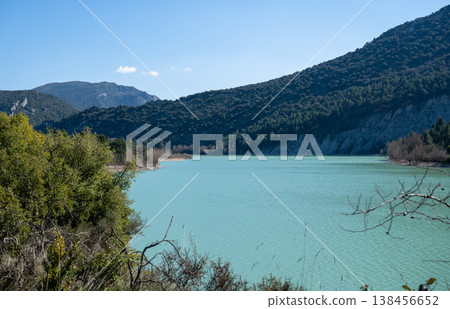 Turquoise lake with mountains and forest under clear blue sky in Spain scenic nature landscape Turquoise lake with mountains and forest under clear blue sky in Spain scenic nature landscape 138456652