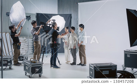 Production staff and models having a meeting on the set of a movie or commercial. 138457208
