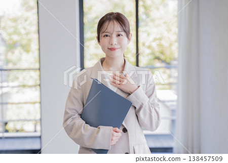 A businesswoman places her hand on her chest in the real estate industry. 138457509