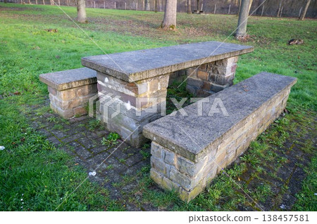 Stone picnic table with benches in park outdoor recreation area rustic furniture nature setting Stone picnic table with benches in park outdoor recreation area rustic furniture nature setting 138457581