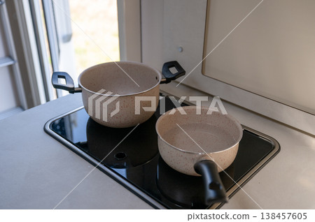Modern kitchen cookware set with saucepan and pot on electric stove minimalist home cooking concept 138457605