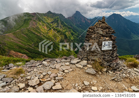 A view of the cloud-filled Yokodake, Akadake, and Amidadake peaks from Ioudake in the Yatsugatake mountain range. 138458105