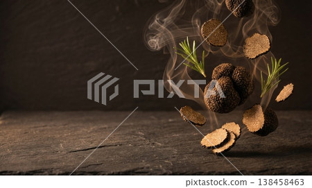 Black truffle with slices and rosemary levitating with smoke on dark background with copy space 138458463