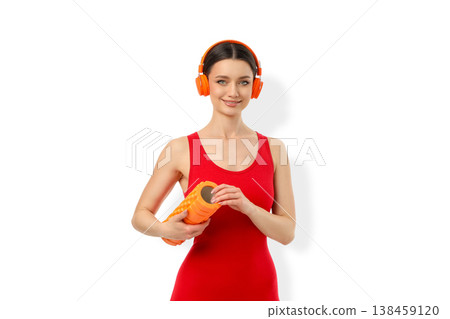 Young woman doing yoga with foam roller and headphones, PNG 138459120
