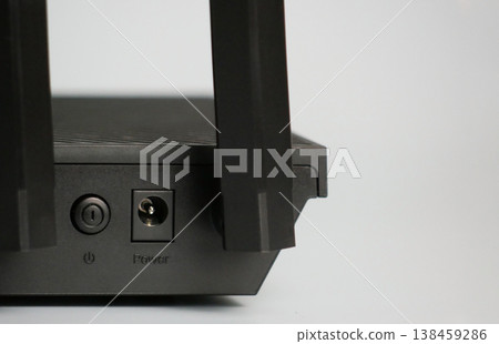 Close-up of a modern WiFi router with antennas and power port. Minimal tech concept for internet connection, networking, smart home, and digital communication 138459286