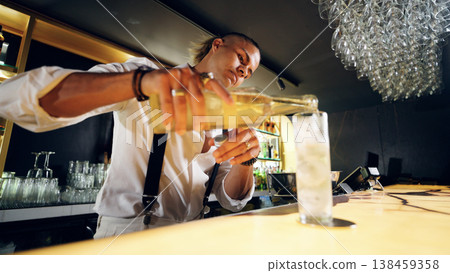 Bartender pouring refreshing cocktail in dark bar Bartender pouring refreshing cocktail in dark bar 138459358