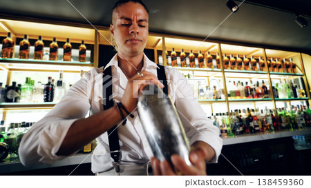 Bartender skillfully mixing drinks at elegant bar Bartender skillfully mixing drinks at elegant bar 138459360