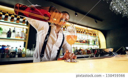 Bartender pouring cocktail into glass at stylish bar Bartender pouring cocktail into glass at stylish bar 138459366