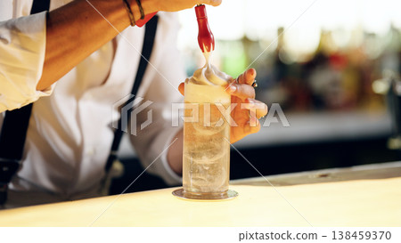 Bartender pouring foam topping on a cocktail drink Bartender pouring foam topping on a cocktail drink 138459370