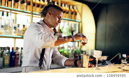 Bartender pouring liquid making cocktail drink at bar Bartender pouring liquid making cocktail drink at bar 138459395