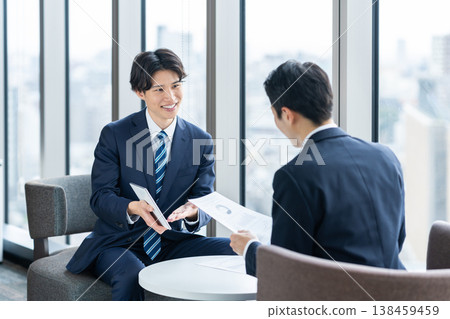 一位年輕的商人正在打電話給客戶推銷產品。拍攝協助單位：電波學園教育基金會、東京電子大學。 138459459