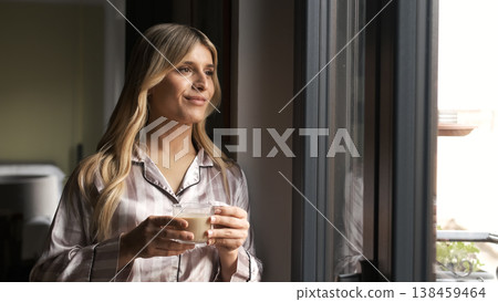 Thoughtful transgender woman holding fresh coffee cup at home Thoughtful transgender woman holding fresh coffee cup at home 138459464