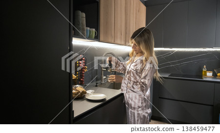 Transgender woman pouring fresh black coffee in glass at kitchen Transgender woman pouring fresh black coffee in glass at kitchen 138459477
