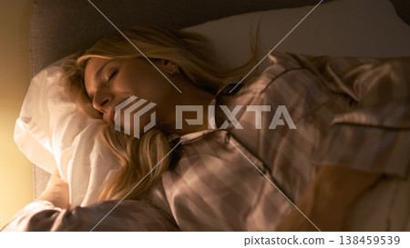 Relaxed transgender woman sleeping on bed in dark bedroom Relaxed transgender woman sleeping on bed in dark bedroom 138459539
