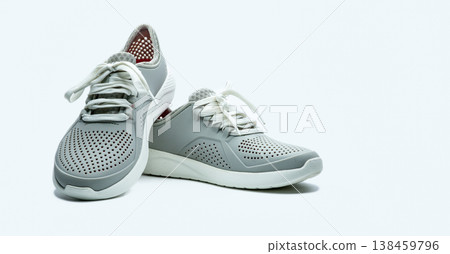 A pair of grey shoes on white background. Comfortable shoes with pore. Breathable rubber shoes. Footwear. A pair of grey shoes on white background. Comfortable shoes with pore. Breathable rubber shoes. Footwear. 138459796