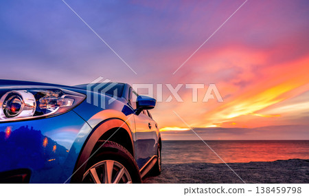 Blue compact SUV car with sport and modern design parked by beach at sunset. Hybrid and electric car technology. Car parking space. Automotive industry. Car care business background. Beautiful sky. 138459798