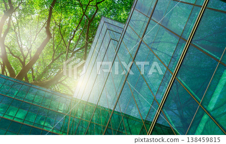 Sustainble green building. Eco-friendly building in modern city. Sustainable glass office building with tree for reducing carbon dioxide. Office with green environment. Corporate building reduce CO2. 138459815