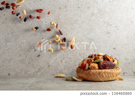 Mix of dried fruits and nuts in motion on a gray background. Mix of dried fruits and nuts in motion on a gray background. 138460860