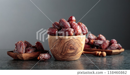 Dates fruit in wooden dish on a black table. 138460862