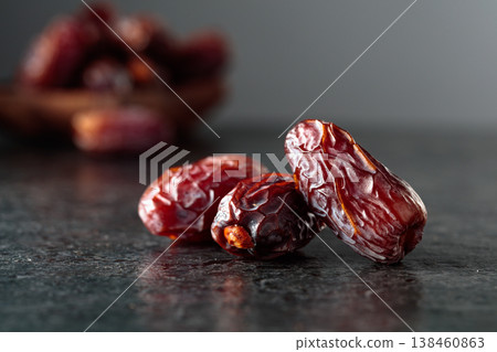 Dried dates fruit on a black table. 138460863