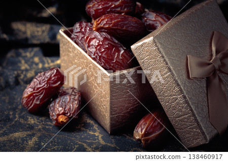 Dates in a gift box on black fabric with gold ornamentation. 138460917