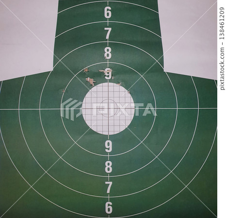 Green paper shooting target with multiple bullet holes in the white bullseye. Concept of precision, expert marksmanship, firearm training, success, and achieving the goal. Green paper shooting target with multiple bullet holes in the white bullseye. Concept of precision, expert marksmanship, firearm training, success, and achieving the goal. 138461209