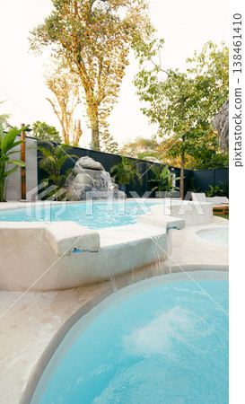 Tropical resort swimming pool with beautiful waterfall Tropical resort swimming pool with beautiful waterfall 138461410