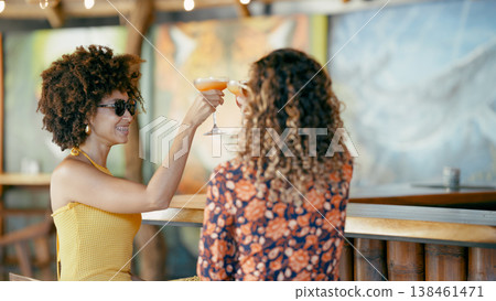 Young women friends toasting cocktails at vacation bar Young women friends toasting cocktails at vacation bar 138461471