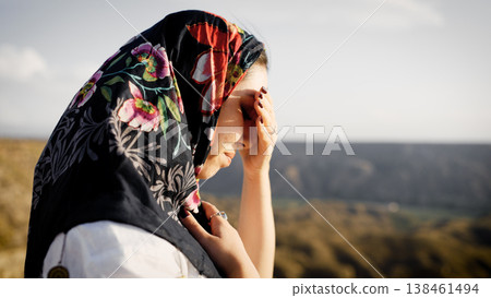 Muslim woman in floral hijab contemplating desert landscape Muslim woman in floral hijab contemplating desert landscape 138461494