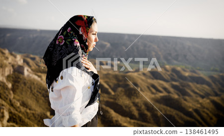 Muslim woman contemplating desert landscape wearing traditional headscarf Muslim woman contemplating desert landscape wearing traditional headscarf 138461495