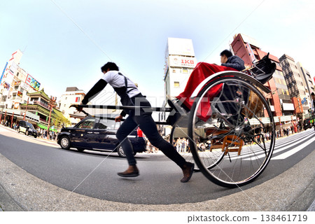 A rickshaw starts moving in front of the Kaminarimon Gate of Senso-ji Temple in Asakusa as the traffic light turns green. 138461719
