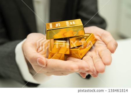Asian woman holding gold bar in finance business. Asian woman holding gold bar in finance business. 138461814