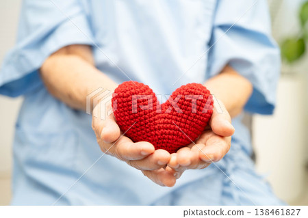 Asian elder senior woman patient holding red heart in hospital. 138461827
