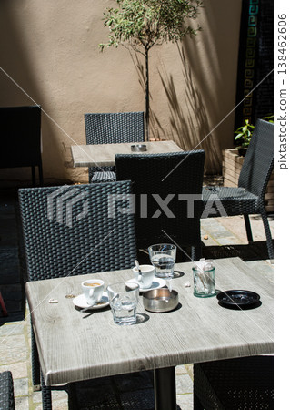 Chairs and tables lined up in a restaurant bathed in bright sunlight; a street scene on the French island of Corsica in the Mediterranean Sea. Chairs and tables lined up in a restaurant bathed in bright sunlight; a street scene on the French island of Corsica in the Mediterranean Sea. 138462606