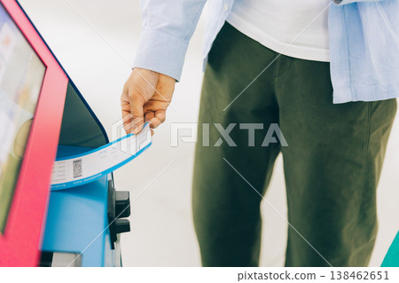 A man's hand performing self-check-in at the airport. (Photo courtesy of Kansai International Airport (KIX)) 138462651