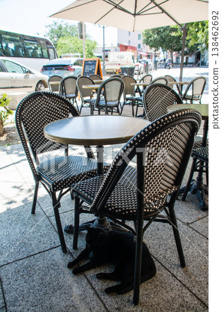 Chairs and tables lined up in a restaurant bathed in bright sunlight; a street scene on the French island of Corsica in the Mediterranean Sea. Chairs and tables lined up in a restaurant bathed in bright sunlight; a street scene on the French island of Corsica in the Mediterranean Sea. 138462692