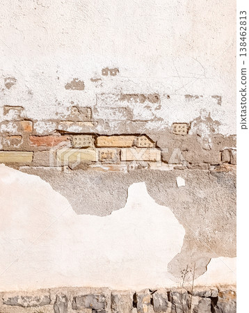 Peeling White Painted Wall with Exposed Old Bricks in Sunlight 138462813