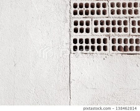 White Painted Wall with Exposed Perforated Bricks 138462814