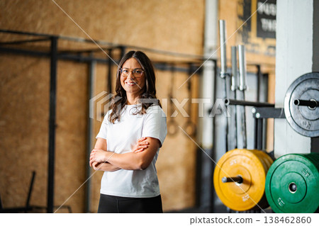 Female personal trainer smiling standing in crossfit gym Female personal trainer smiling standing in crossfit gym 138462860